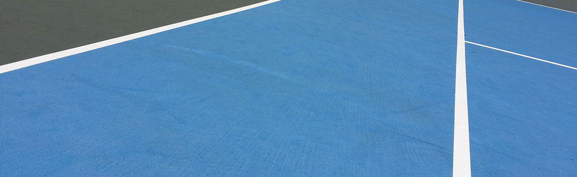 A tennis court with blue tarp covering the surface.